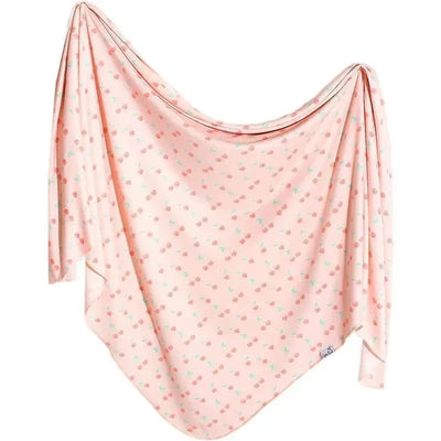 Cheery pink baby swaddle blanket decorated with small floral patterns, ideal for newborns.