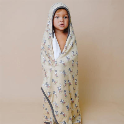 Hooded towel with Disney Princess pattern, wrapped around a child, showcasing a soft interior and vibrant design.
