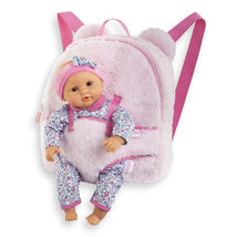 Plush pink backpack designed as a baby doll carrier with a doll in floral pajamas and a matching headband.