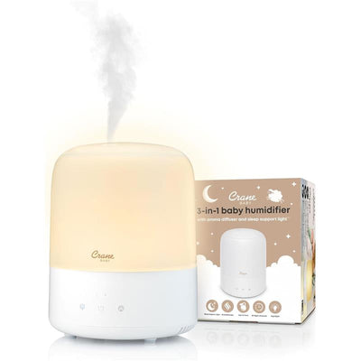 Crane 3-in-1 pediatric humidifier with aroma diffuser and sleep support light, emitting mist with product packaging behind.