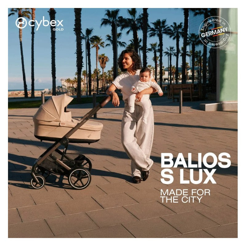 A woman walks with a Cybex Balios S Lux stroller in Almond Beige while holding a baby, against a palm tree backdrop.