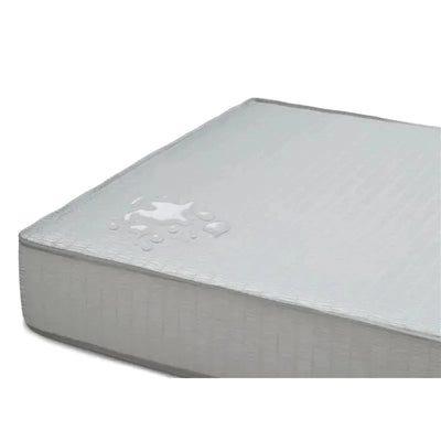 Hybrid crib and toddler mattress by Delta Children, featuring a waterproof surface with a visible water splash.