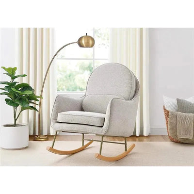 Grey rocking chair upholstered in LiveSmart Evolve fabric, featuring plush cushions and wooden rockers, set in a bright room.