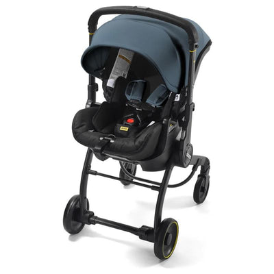 Doona X Infant Car Seat in Ocean Blue with a black base, featuring a safety harness and adjustable canopy.
