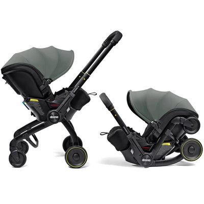Doona X Infant Car Seat in Slate Green, featuring a removable canopy and integrated wheels for easy transport.