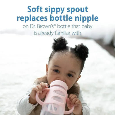 Light pink sippy spout bottle with silicone handles held by a child, featuring text about replacing bottle nipples.