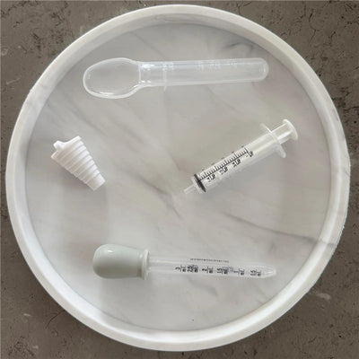 Dreambaby Medicine Set includes a syringe, measuring spoon, dropper, and pill cutter, all arranged on a round tray.
