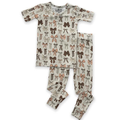 Pajama set featuring a short-sleeve top and full-length pants, decorated with various bows in shades of pink and brown.