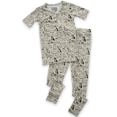 A baby pajama set featuring a short-sleeve top and matching pants, both printed with various dog illustrations.