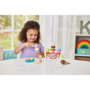 Child scooping colorful toy ice cream with a scoop, surrounded by an ice cream party playset.