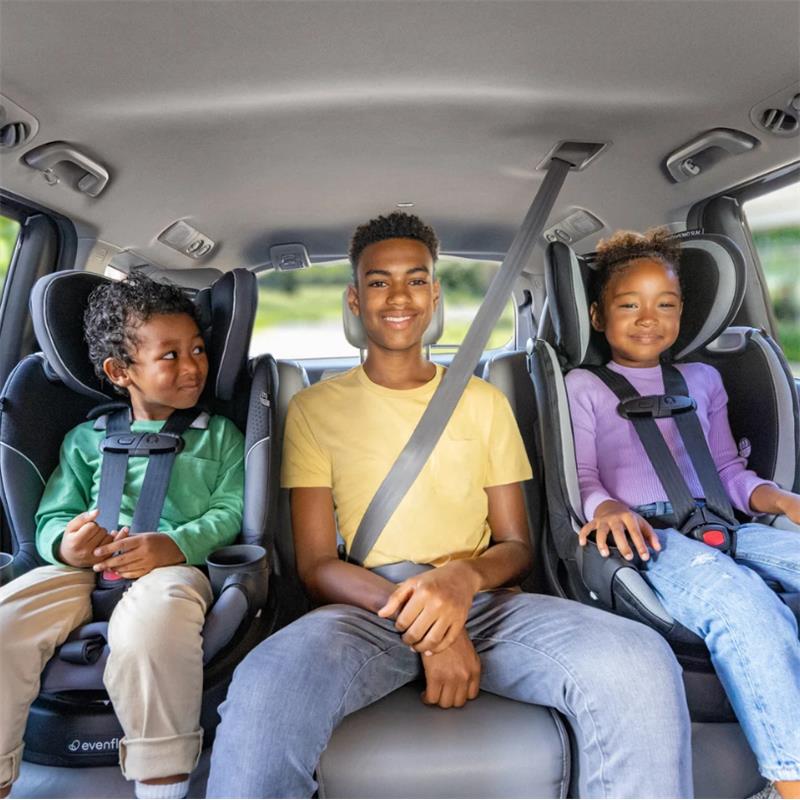 Three children seated in Evenflo Revolve360 Slim 2-in-1 Rotating Convertible Car Seats in the back of a vehicle.