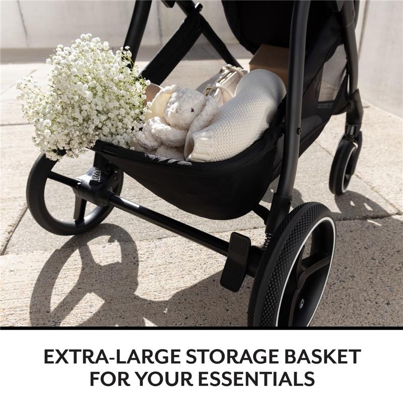 Extra-large storage basket in an Evenflo Shyft Intuiti Travel System, filled with flowers, a plush toy, and essentials.