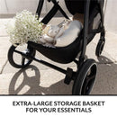 Extra-large storage basket in an Evenflo Shyft Intuiti Travel System, filled with flowers, a plush toy, and essentials.