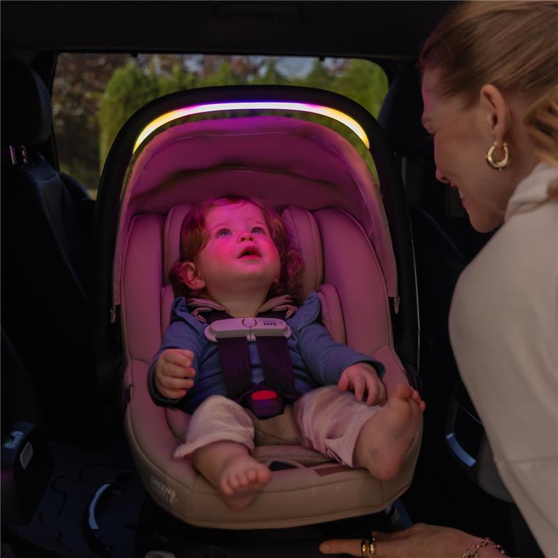 Infant sitting in Evenflo Revolve180 LiteMax NXT car seat with ambient lighting, while a woman interacts with the child.