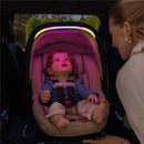 Infant sitting in Evenflo Revolve180 LiteMax NXT car seat with ambient lighting, while a woman interacts with the child.