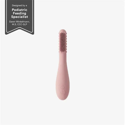 Baby-Led™ Toothbrush by Ezpz in blush color, featuring textured silicone bristles and a sleek ergonomic handle.