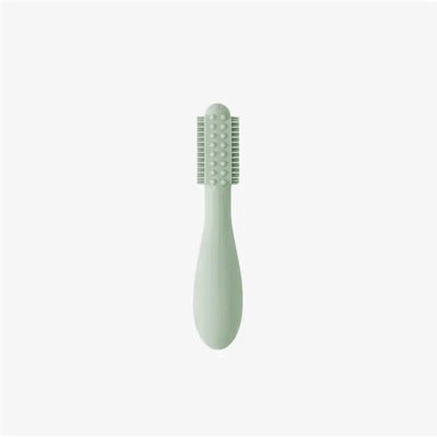 Sage-colored Baby-Led™ toothbrush designed for infants, featuring a textured grip and soft bristles for gentle cleaning.