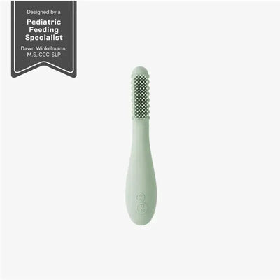 Sage-colored Ezpz Baby-Led™ Toothbrush with textured bristles, designed for infants to promote self-feeding and oral care.