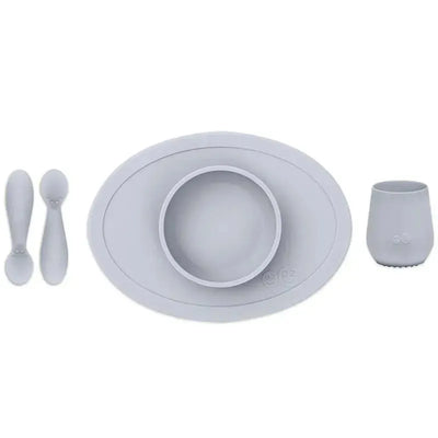 Ezpz First Foods Set in pewter color, includes a suction bowl, two spoons, and a cup, designed for baby feeding.