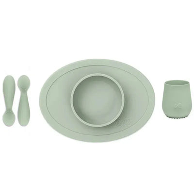 Ezpz First Foods Set in sage color includes a suction plate with bowl, two spoons, and a cup designed for infants.