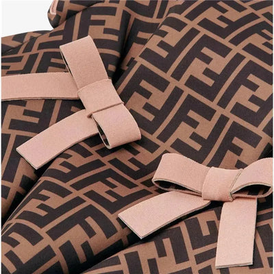 Baby dress featuring an all-over Fendi logo pattern in brown with two pink blush bows. Designed for infants, size 12M.