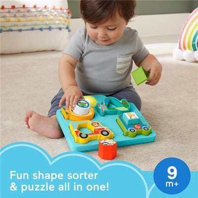 Baby playing with Fisher Price shape sorter puzzle featuring colorful vehicle shapes, sounds, and lights, suitable for 9 months and up.