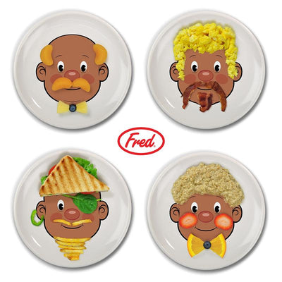 Ceramic dinner plates by Fred & Friends, featuring cartoon faces that create playful food arrangements.