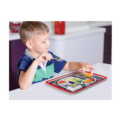 A young boy is using a spoon to eat from a divided superhero-themed dinner tray filled with various foods.