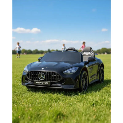 24V black Mercedes AMG GT63 ride-on car on green grass, featuring a detailed front grille and sporty design.