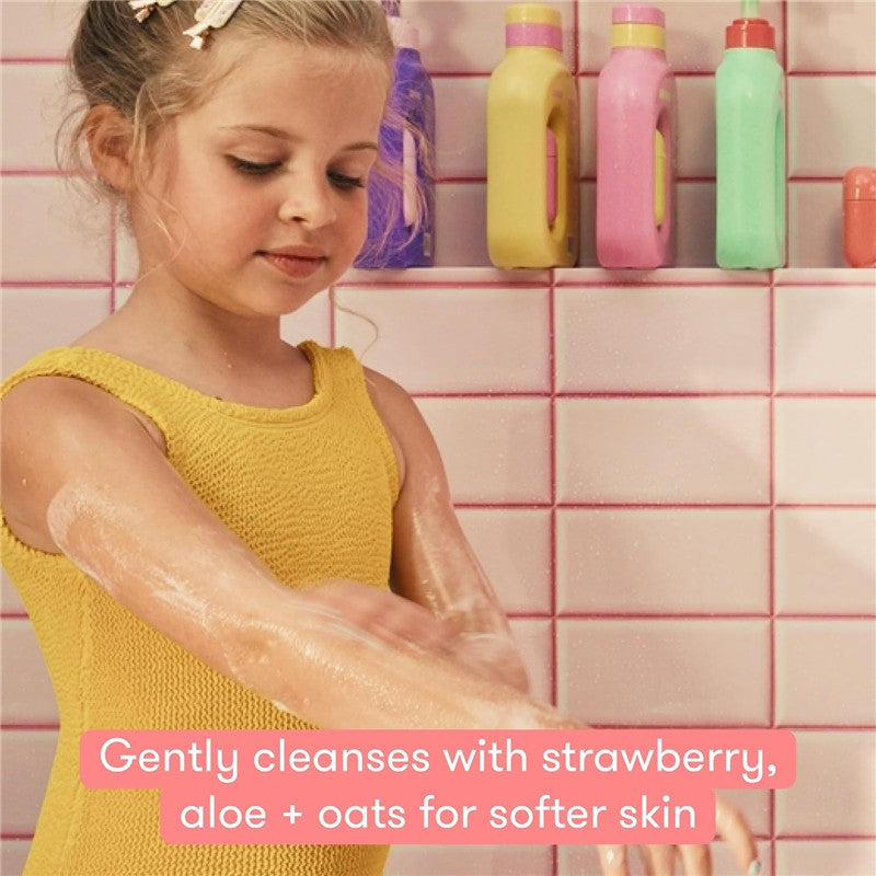 Young girl applying Frida for Kids Body Wash on her arms, surrounded by colorful bottles in a bathroom setting.