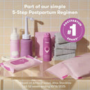 Frida Mom postpartum care products including disposable underwear, sprays, wipes, and towels on a light tile background.