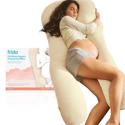 Frida Mom Full Body Support Cooling Pregnancy Pillow, designed for pregnant women, shown with a model in a relaxed sleeping position.