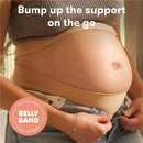 Frida Mom Belly Band providing support for a pregnant belly, woman adjusting the band while wearing jeans.