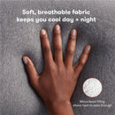 Soft, breathable gray fabric of Frida Mom Pregnancy Body Pillow, hand resting on it with text highlighting cooling features and micro-bead filling.