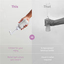 Gray Frida Mom Upside Down Peri Bottle sprayer held in hand, comparing with a ketchup bottle for postpartum care.