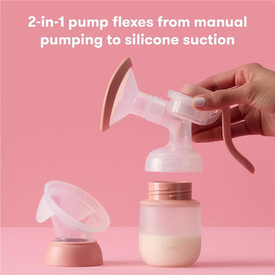 2-in-1 Fridababy manual and silicone suction breast pump with interchangeable parts on a pink background.