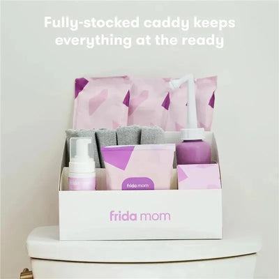 Fully-stocked Fridababy Mom Postpartum Recovery Essentials Kit on a bathroom countertop, featuring various recovery products in a caddy.