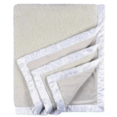 Plush neutral-colored blanket featuring a soft fleece surface and a celestial-patterned border.