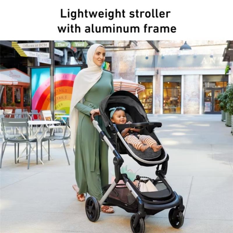 Lightweight Graco Modes Nest Travel System stroller in Sullivan, featuring a baby with a bow, pushed by a woman in a green outfit.