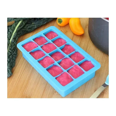 Pink Green Sprouts Fresh Baby Food Freezer Tray filled with pureed food, surrounded by vegetables on a wooden surface.