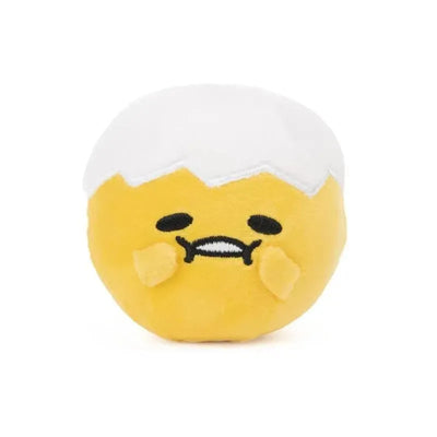 Round yellow Gudetama plush with a white shell, featuring a smiley face and outstretched arms, conveying a relaxed expression.