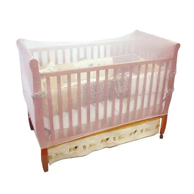 White crib mosquito net draped over a wooden crib with patterned bedding and a decorative skirt.