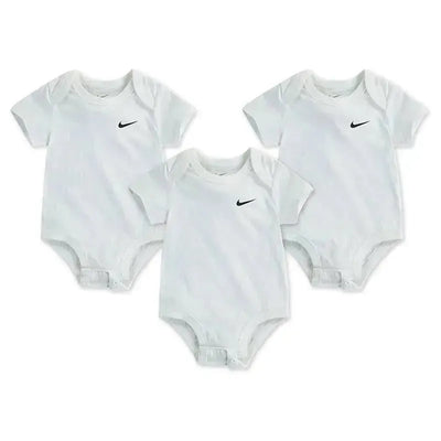 Three white Nike bodysuits for infants, each featuring a small black Nike logo on the front.