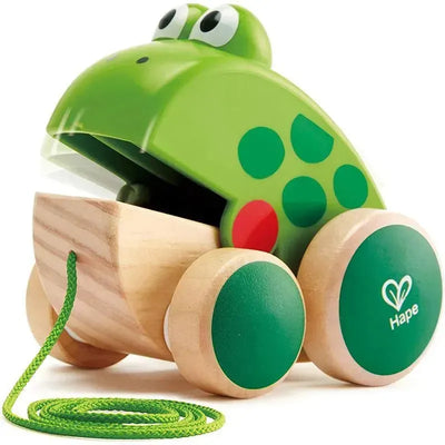 Green frog-shaped wooden pull toy with a smiling face, featuring a rope and colorful dots on its body.