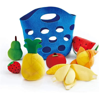 Toddler-sized colorful plush fruits including a pineapple, pear, tomato, and watermelon, arranged around a blue felt basket.