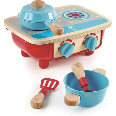 Toy kitchen set featuring a red and blue stove, a pot, wooden utensils, and a blue mixing bowl.