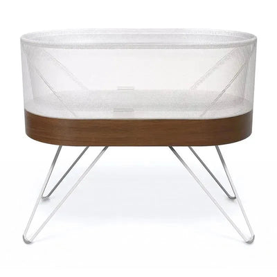 SNOO Smart Sleeper Bassinet with a wooden base and mesh sides, designed to soothe babies for better sleep.