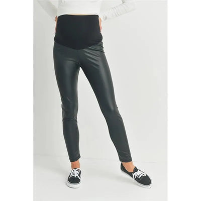 Faux leather maternity leggings with a black over-the-bump waistband, styled with a white top and black shoes.