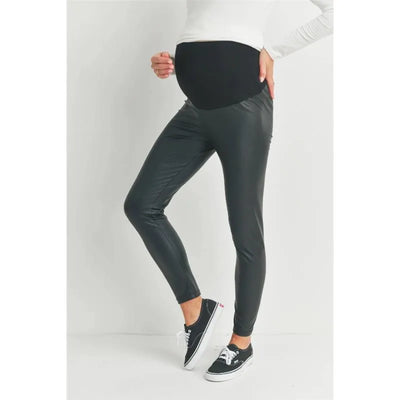 Faux leather black maternity leggings designed to fit over the bump, worn by a model in a casual outfit.