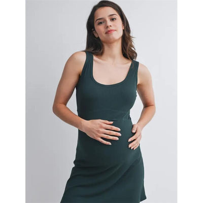 Ribbed maternity active mini dress in hunter green worn by a pregnant woman touching her belly, showcasing comfort and style.